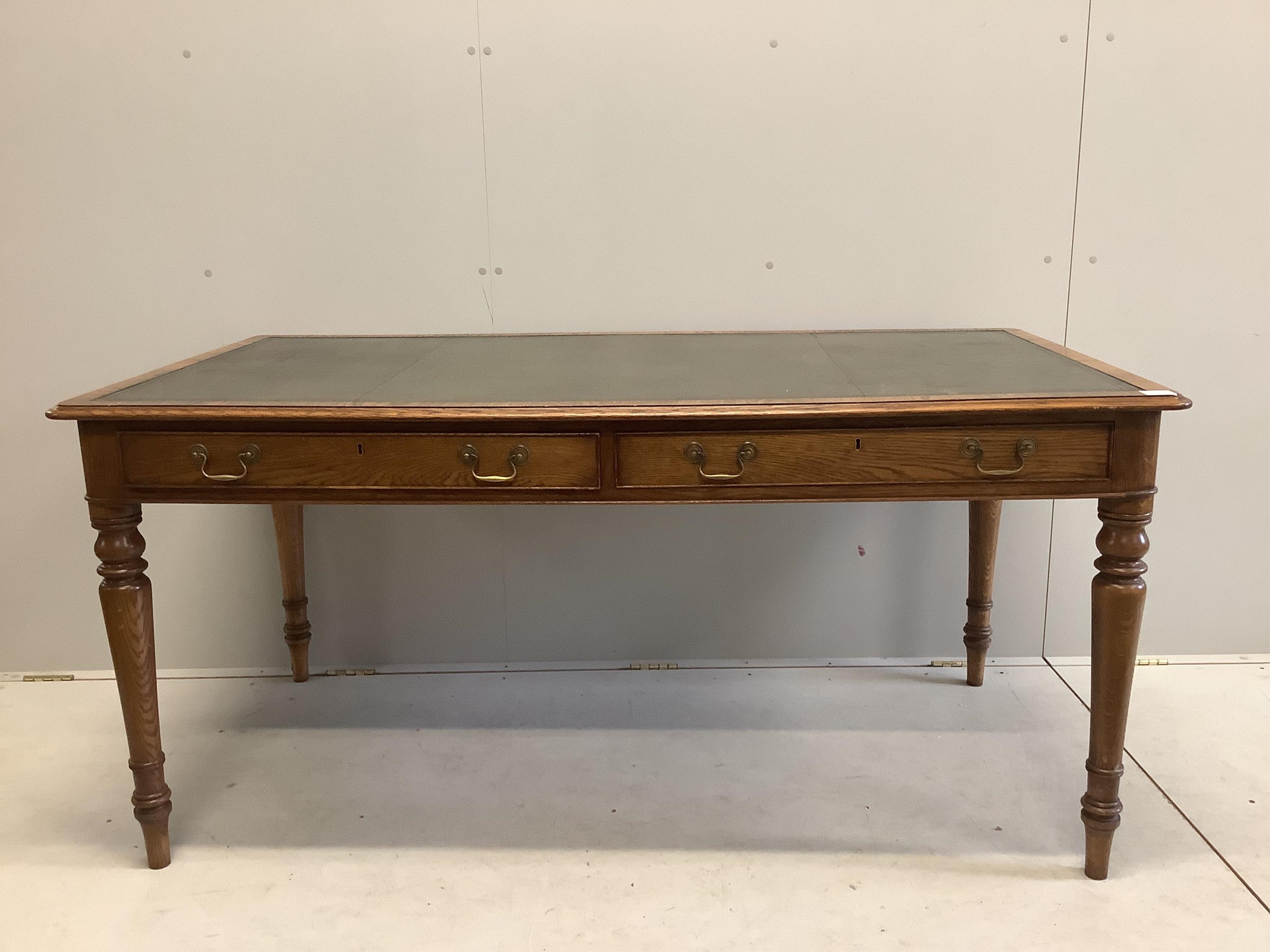 A reproduction Victorian style oak two drawer writing table, width 160cm, depth 84cm, height 76cm. Condition - good